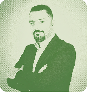 A smiling businessman in a green suit.