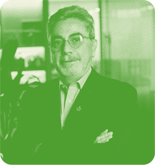 A middle-aged man with a warm smile, wearing a dark suit.